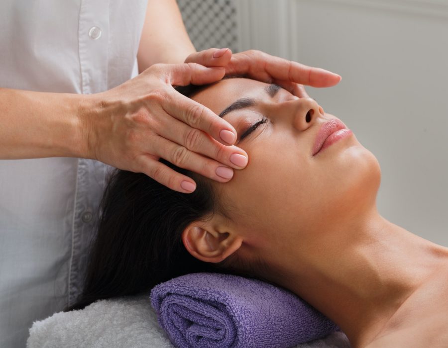 Woman massagist make face lifting massage in spa wellness center